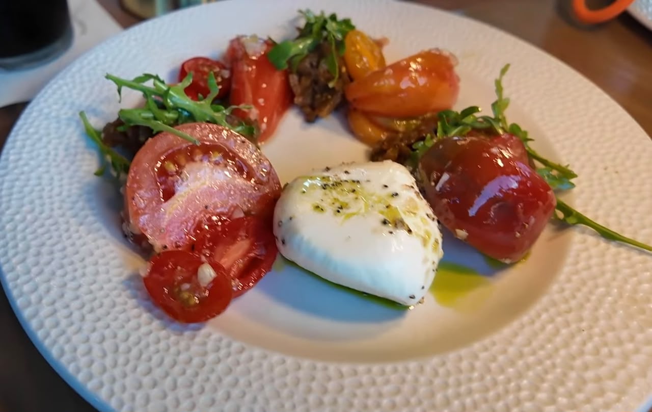Burrata cremosa com tomates e torradas, prato do Restaurante Atlantic no Epic Universe